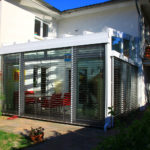 ogród zimowy z odsłoniętymi żaluzjami