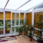 ogród zimowy z żółtymi żaluzjami