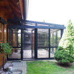 ogród zimowy z czarnymi żaluzjami