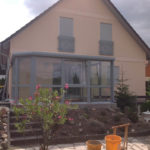 szary ogród zimowy z płaskim zadaszeniem