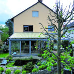 zacieniony ogród zimowy z widokiem na staw